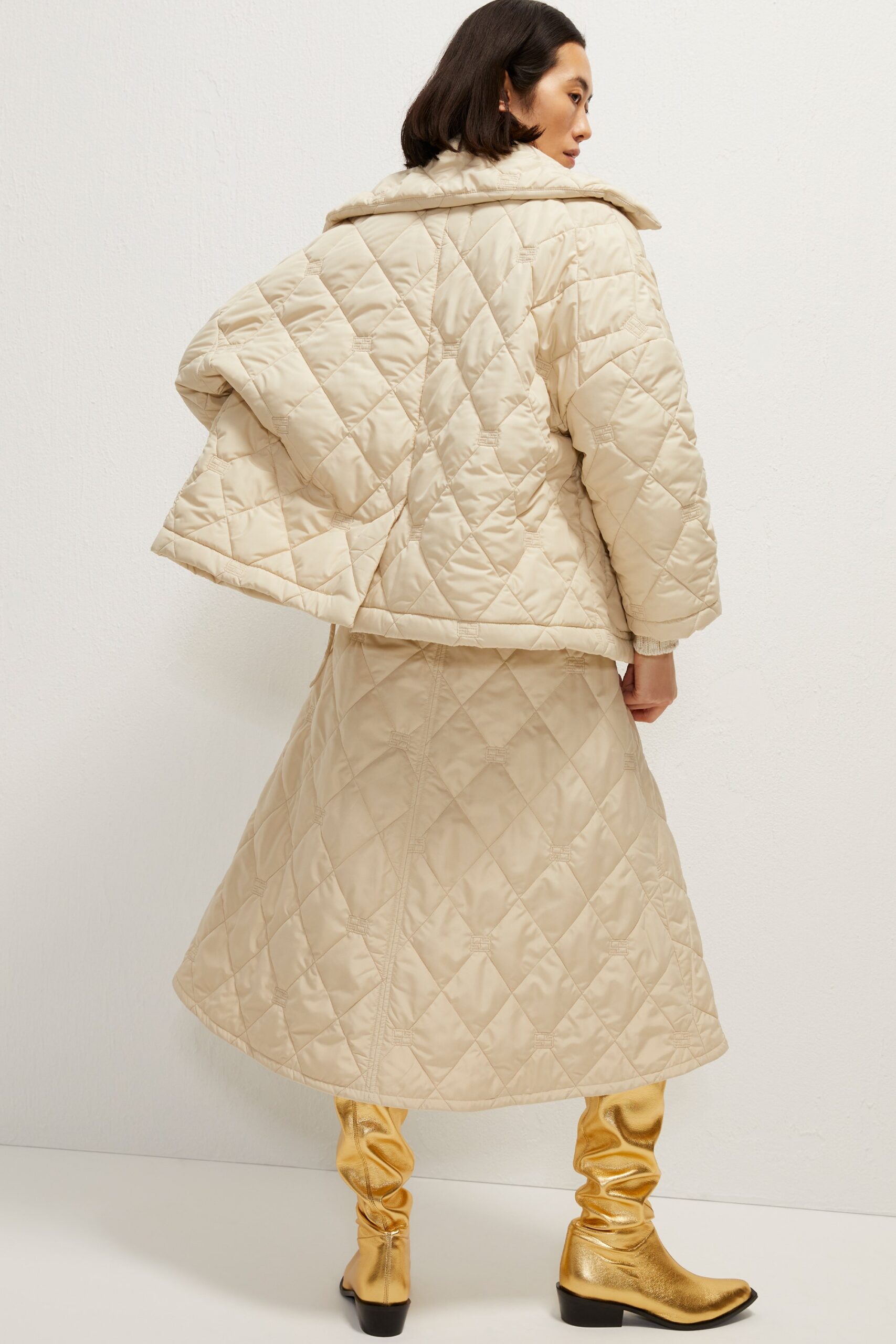 beige quilted coat and skirt with gold boots