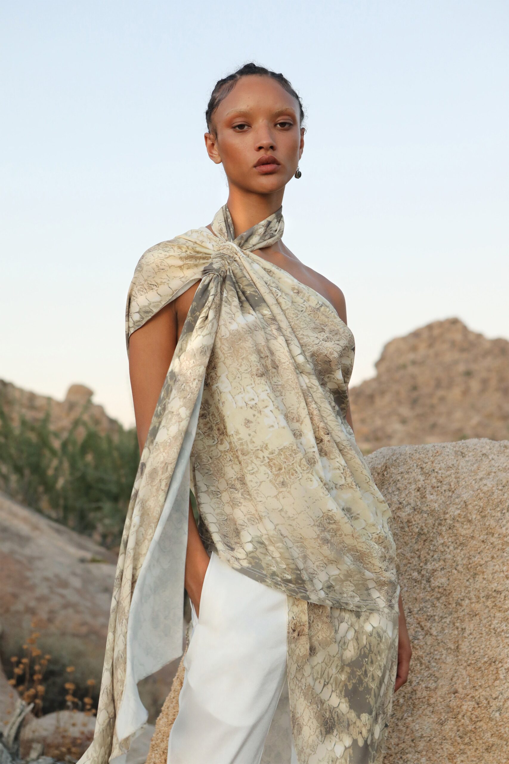 beige silk draped top with white pants