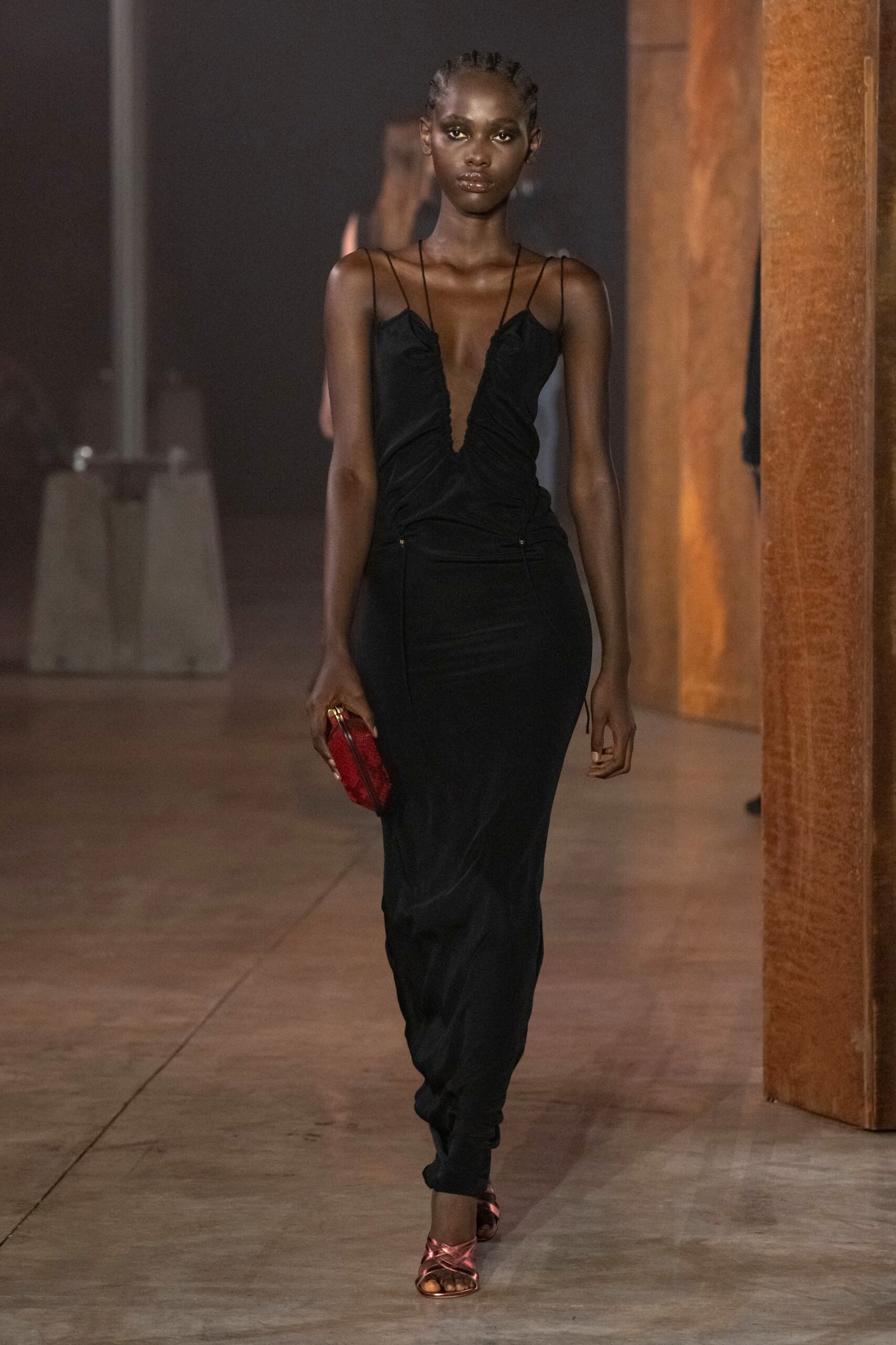 black silk sleeveless dress with red clutch