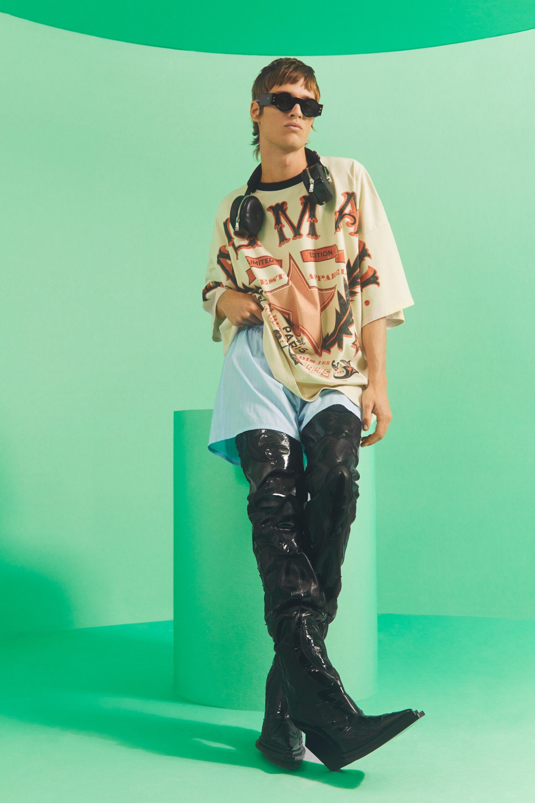 beige printed t-shirt with black vinyl pants