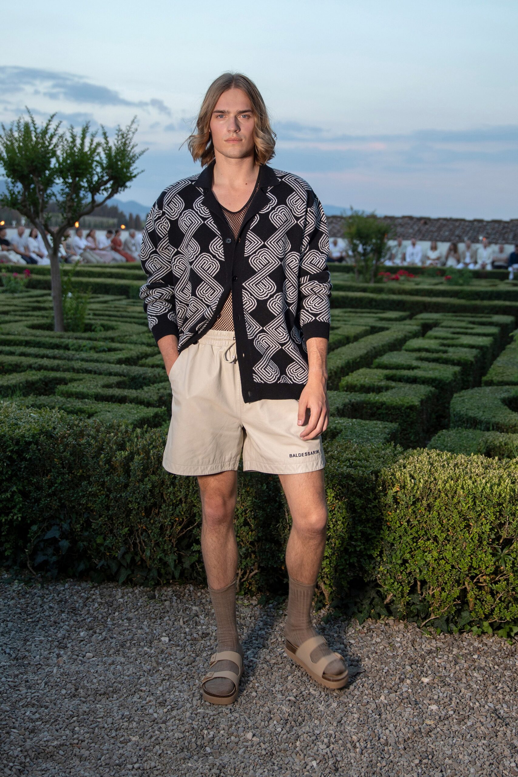 black and white printed shirt with beige shorts