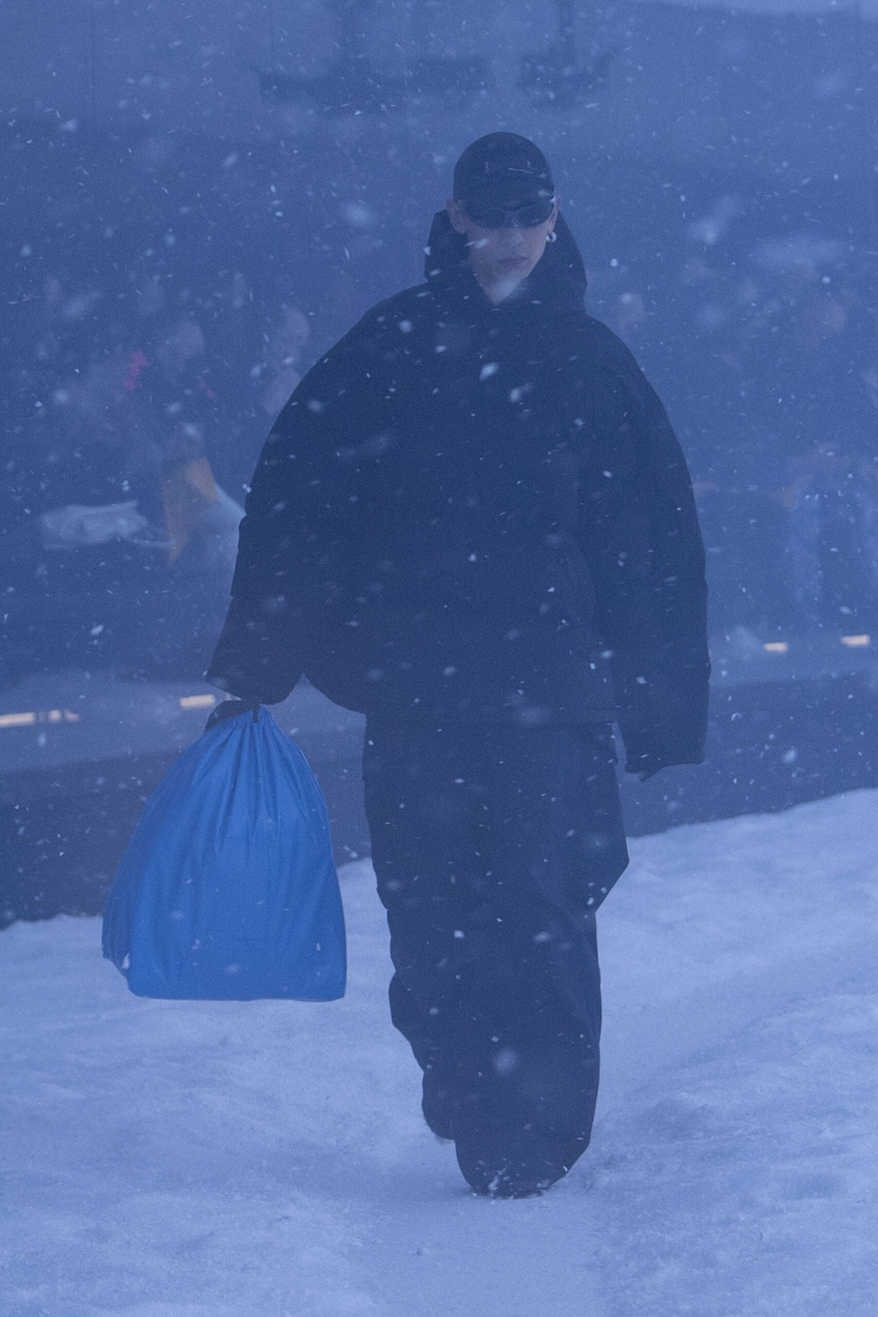 oversized black coat and blue bag