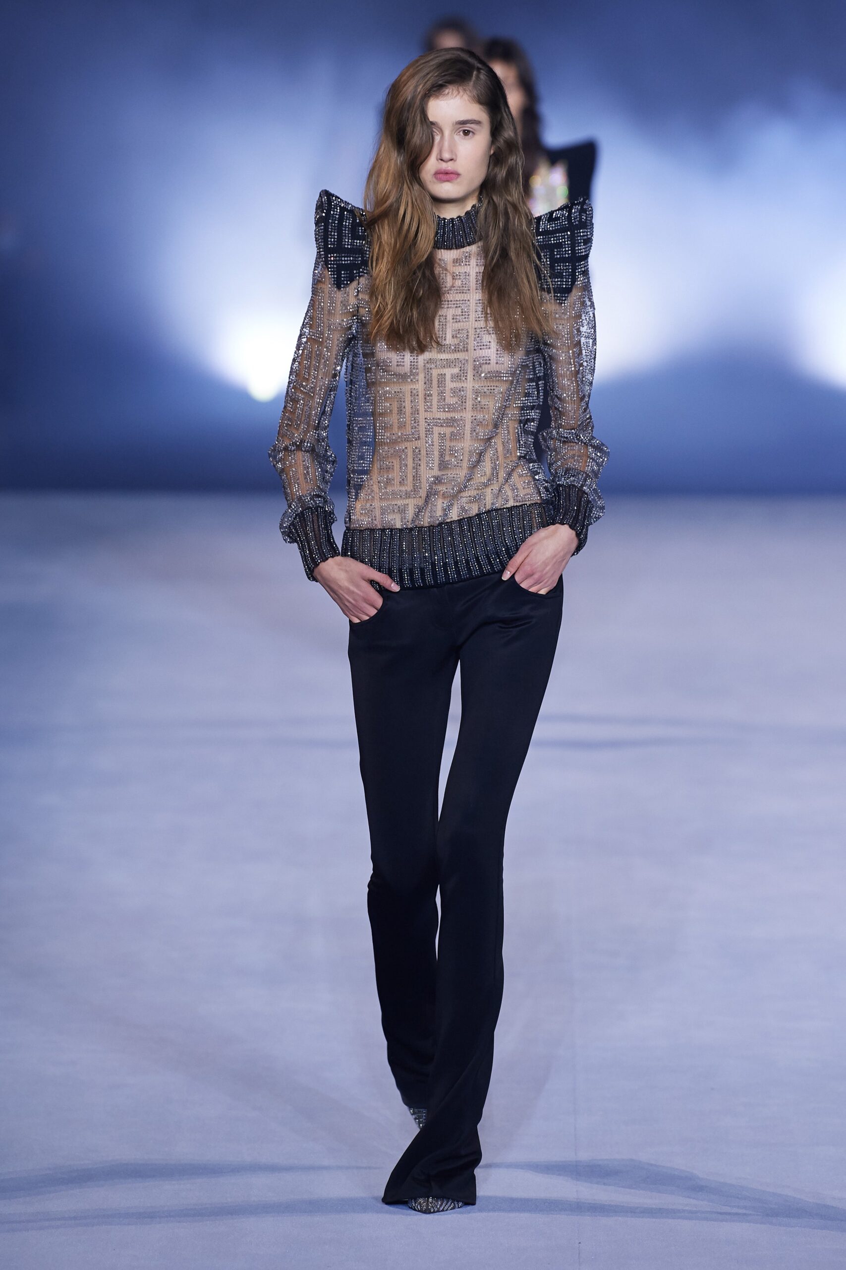 beige sheer ruffled top with black pants