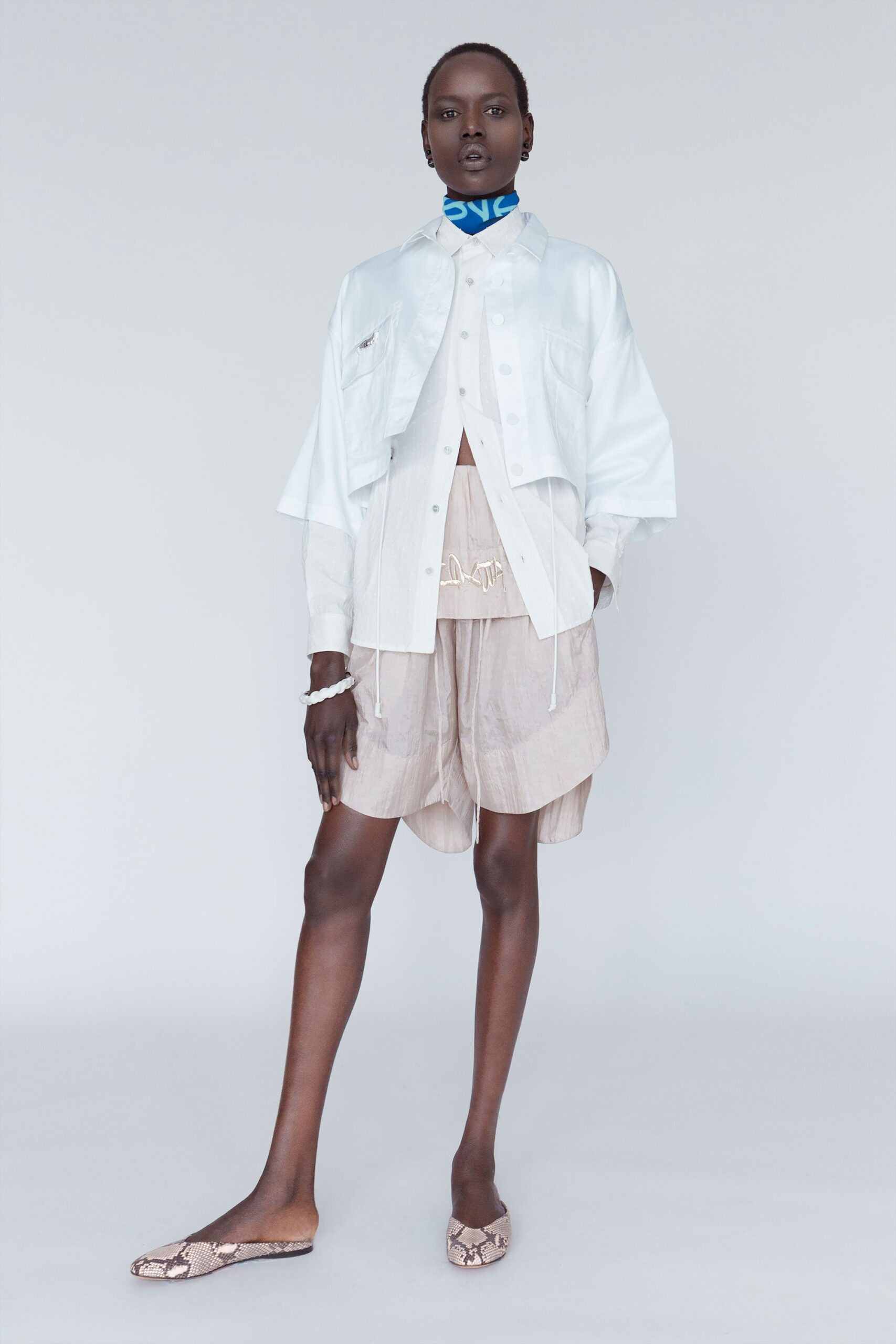 white relaxed jacket with beige top and shorts