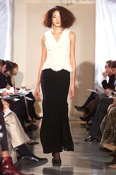white ruffled top and black pleated skirt
