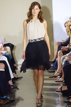 white silk sleeveless blouse and black pleated mini skirt
