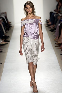 purple silk off-shoulder top and white pleated skirt