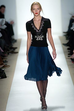 black fitted top with blue pleated skirt