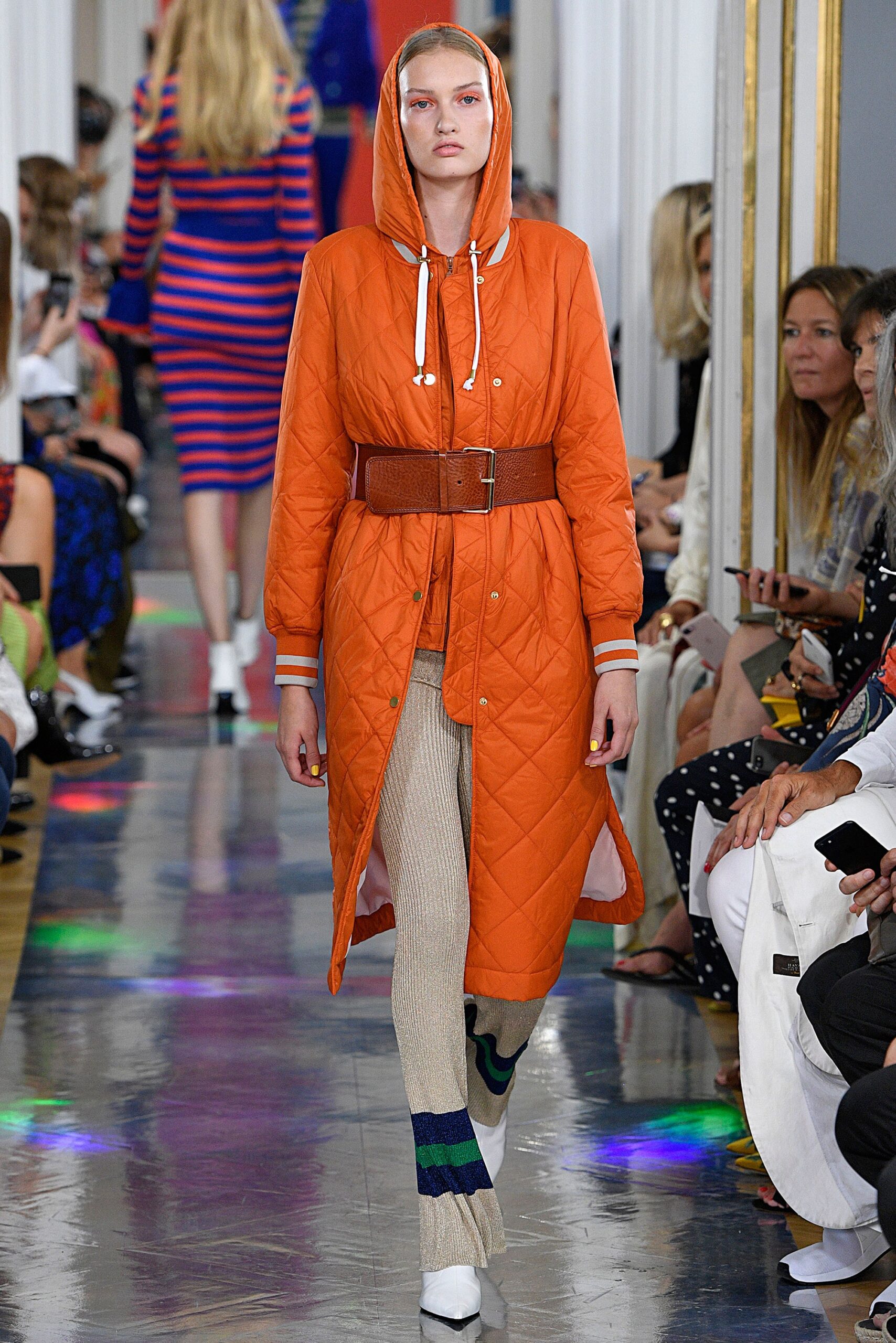 orange quilted coat with beige pants