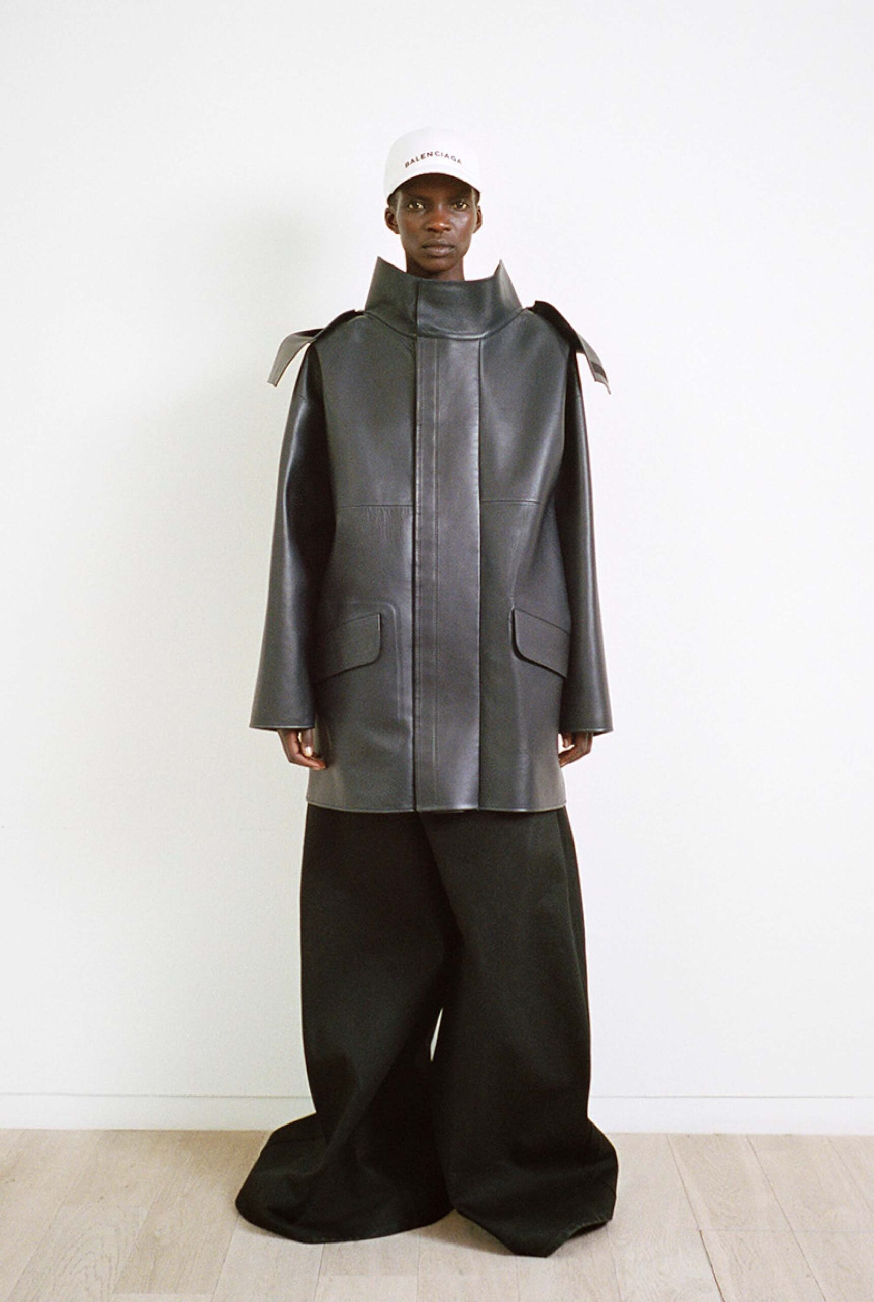 oversized black leather coat and relaxed pants