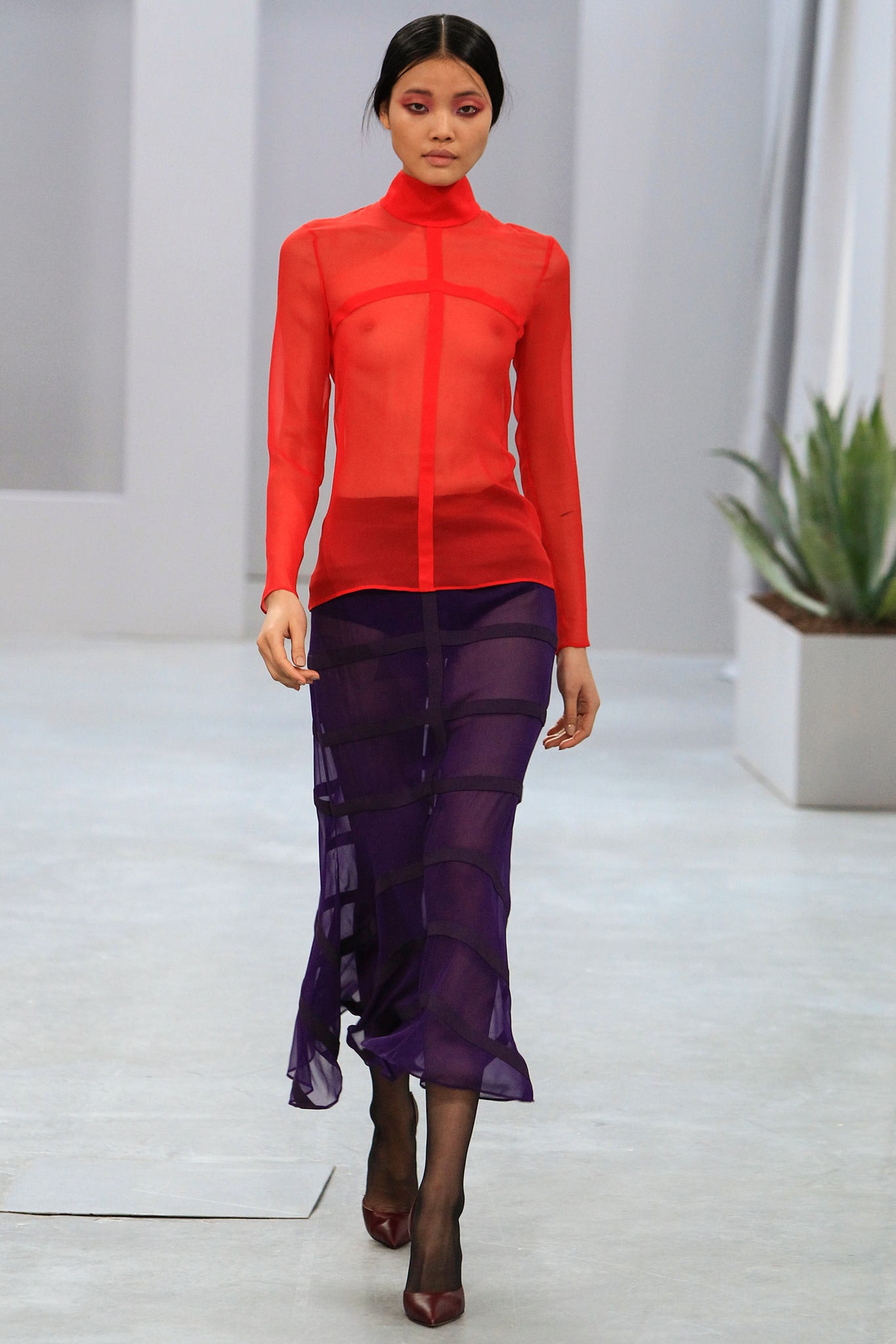 red sheer top with purple skirt