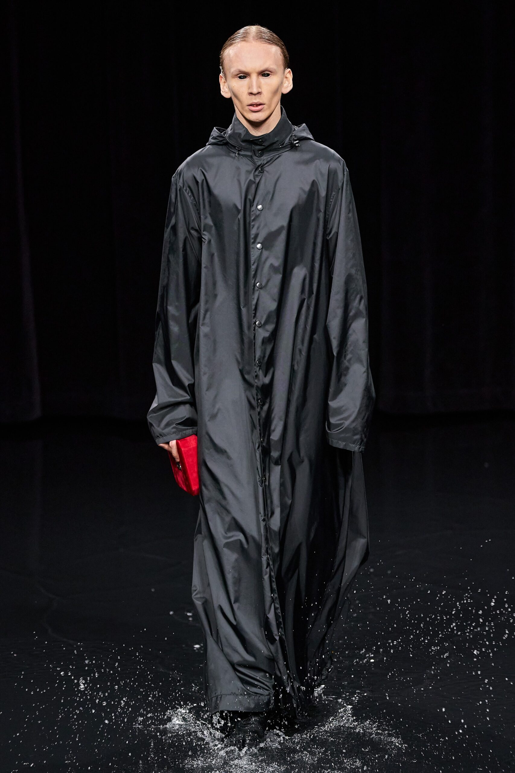 oversized black vinyl coat with red bag