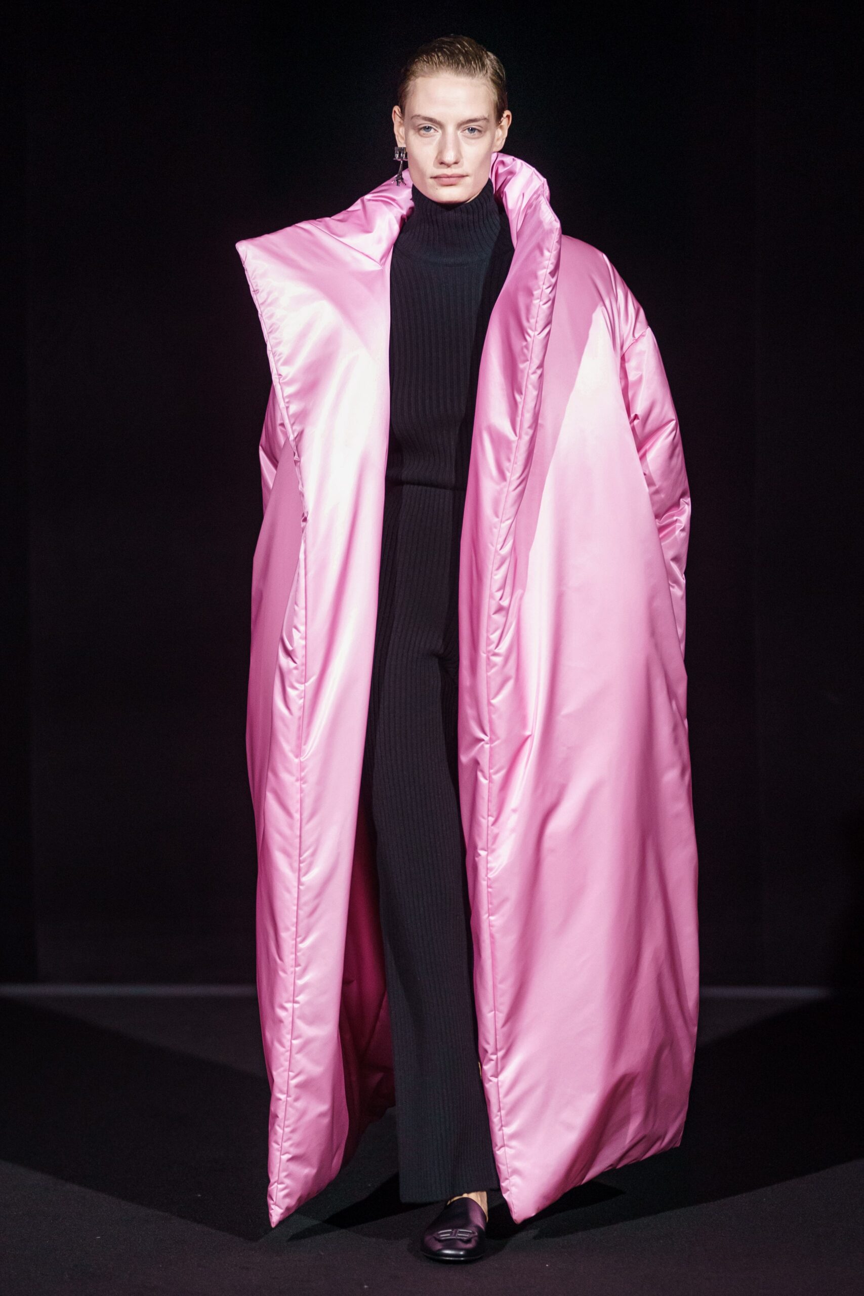 pink oversized padded coat and black fitted dress