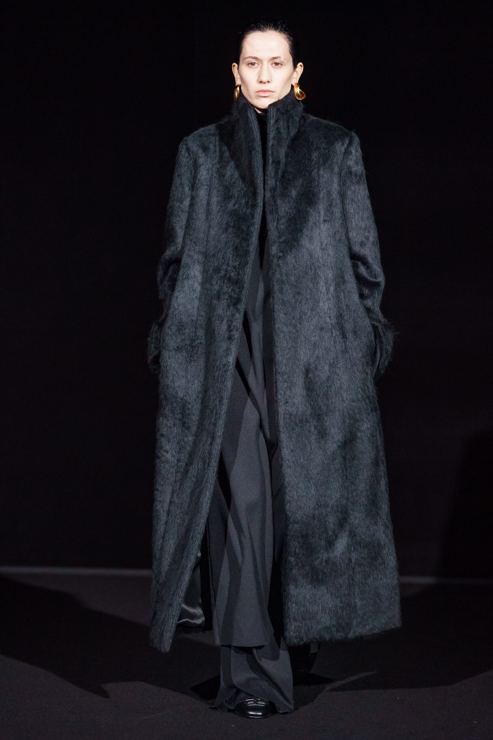 black faux-fur coat and fitted pants