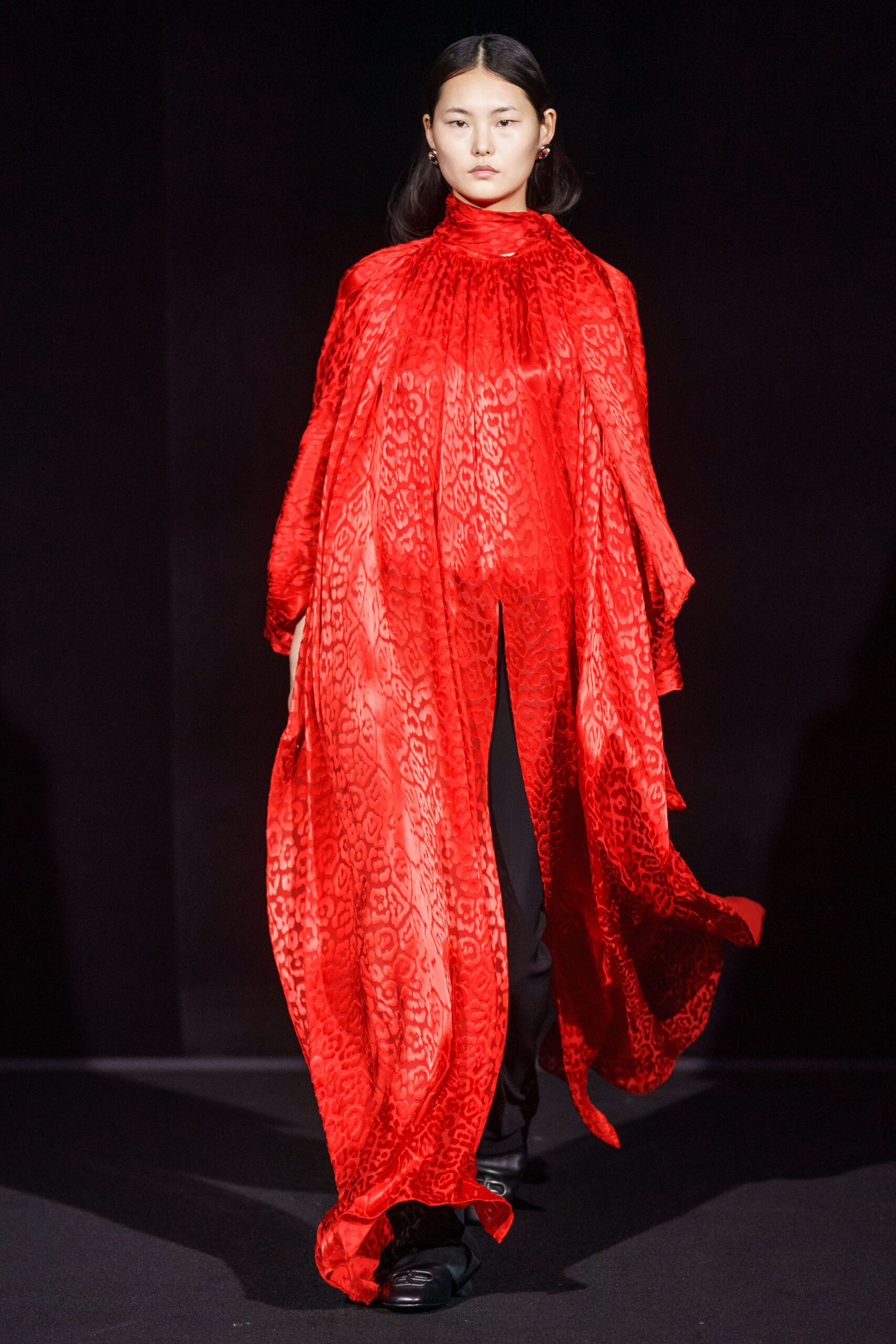 red silk draped cape with black pants
