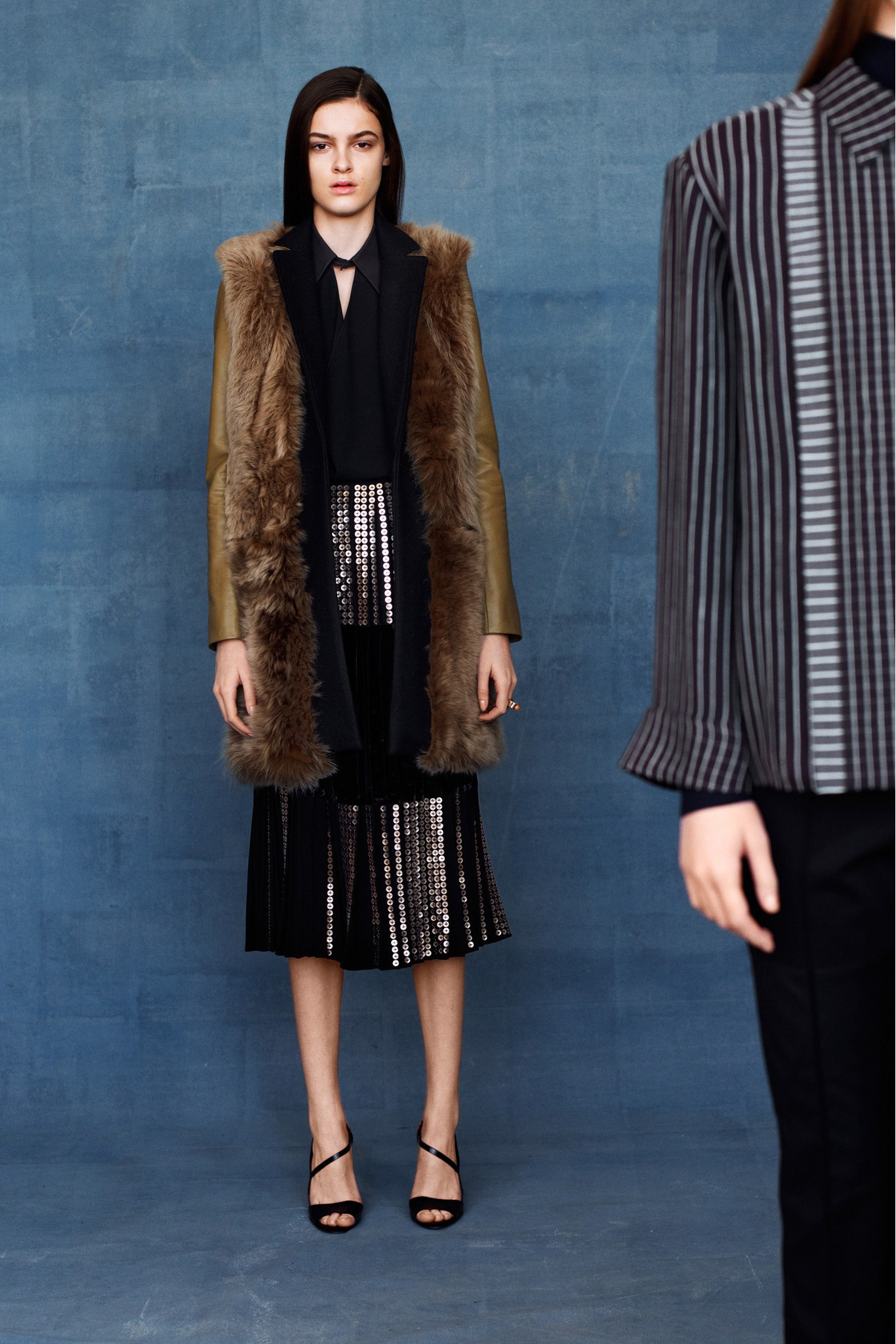 brown leather fur coat with black blouse and pleated skirt