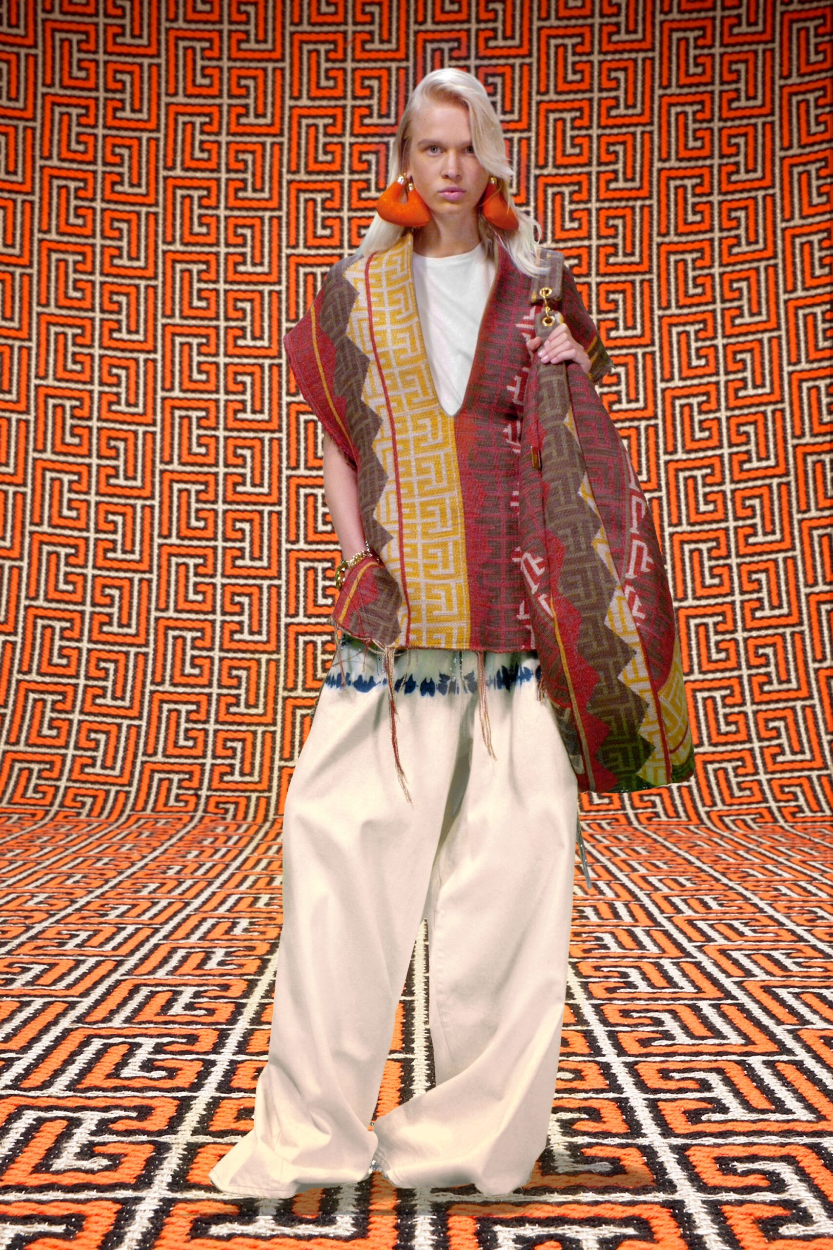 relaxed red poncho and white pants