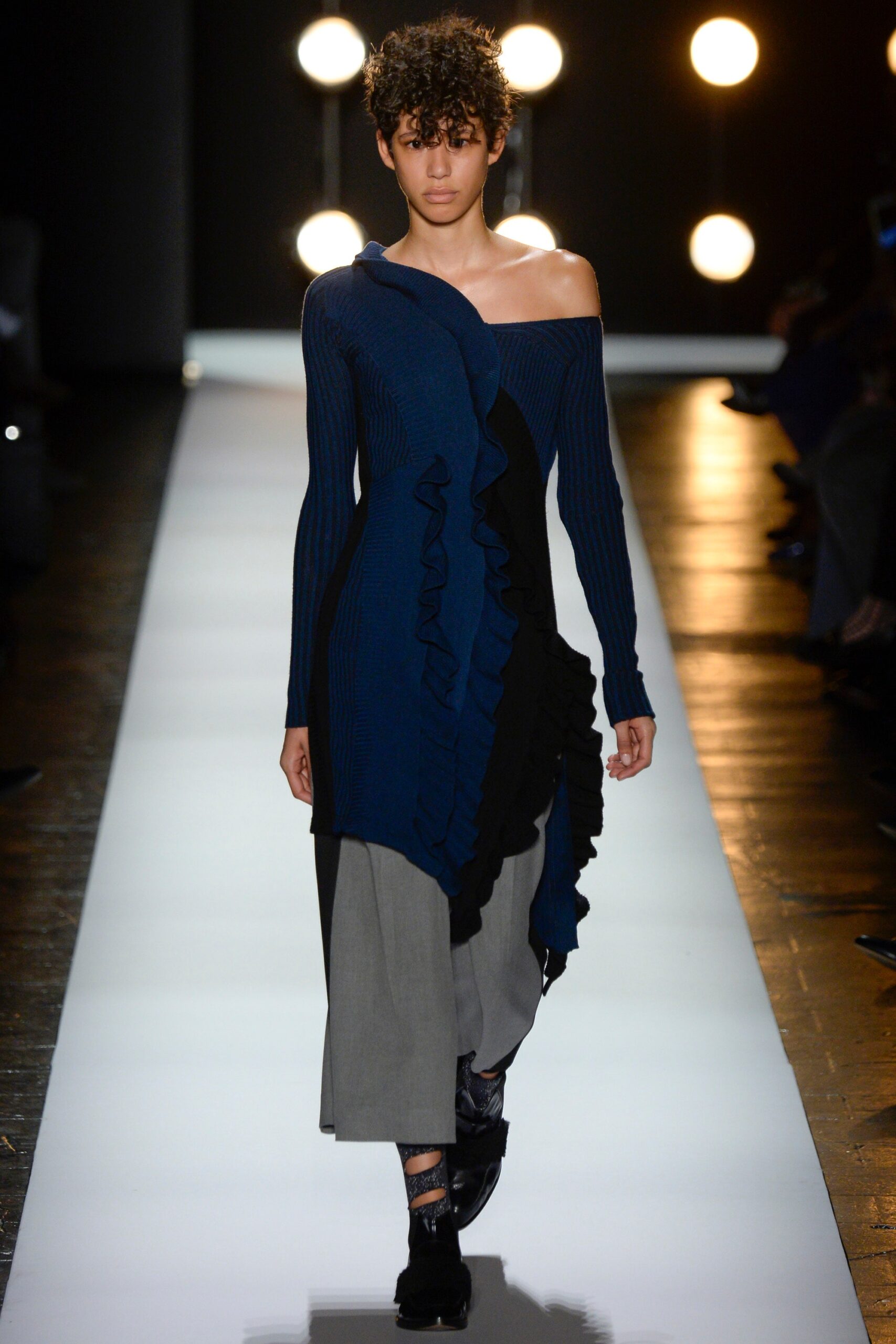 blue off-shoulder ruffled top with gray pants