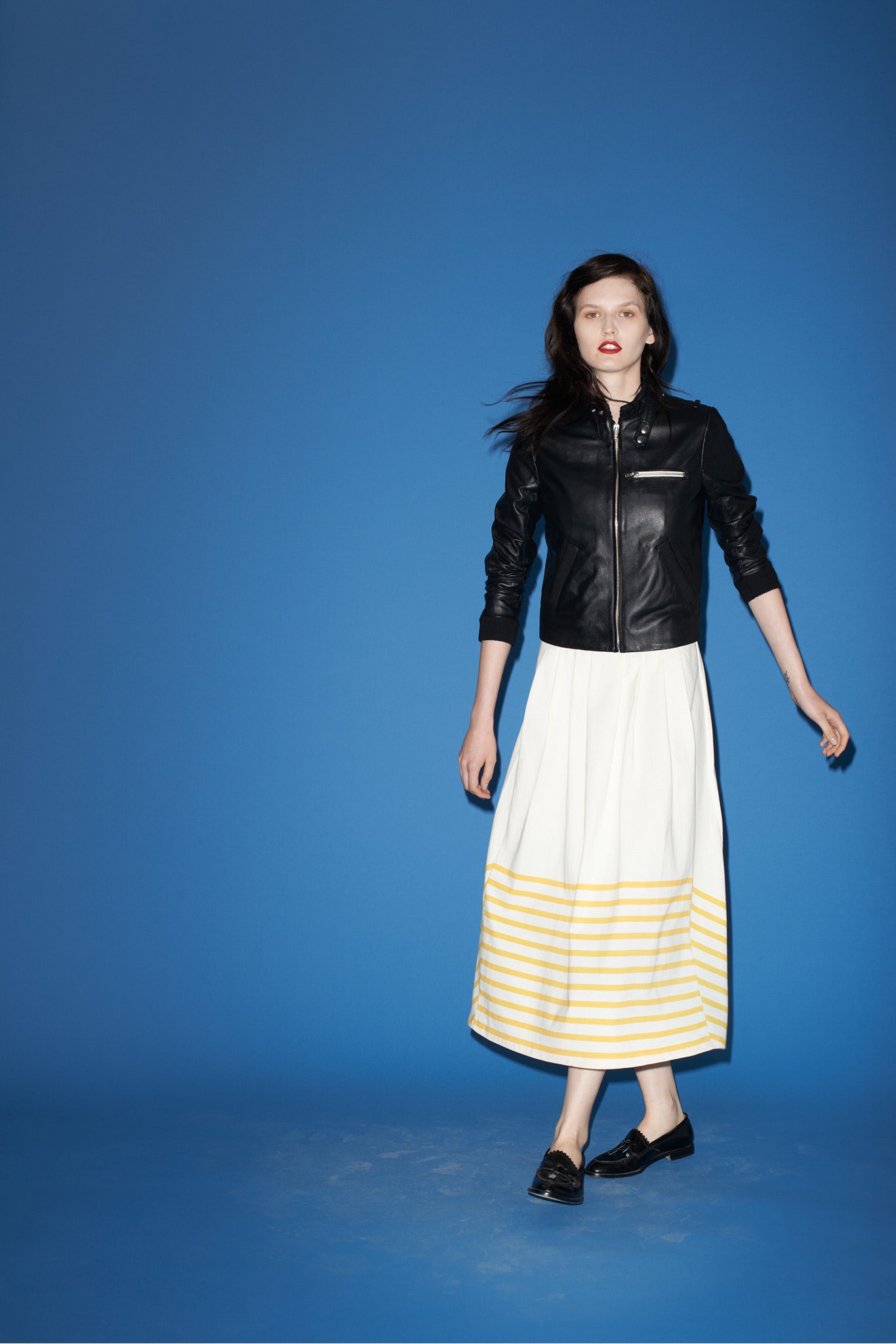 black leather fitted jacket and striped midi skirt