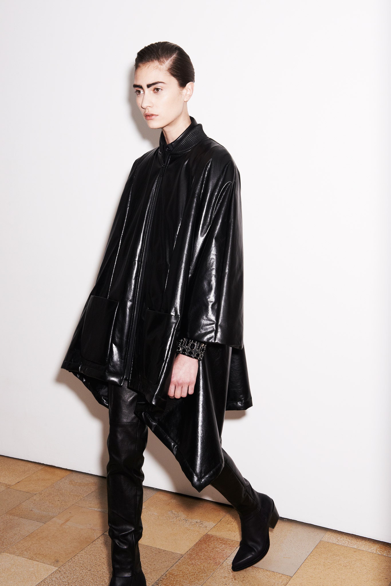 black leather oversized poncho and fitted pants