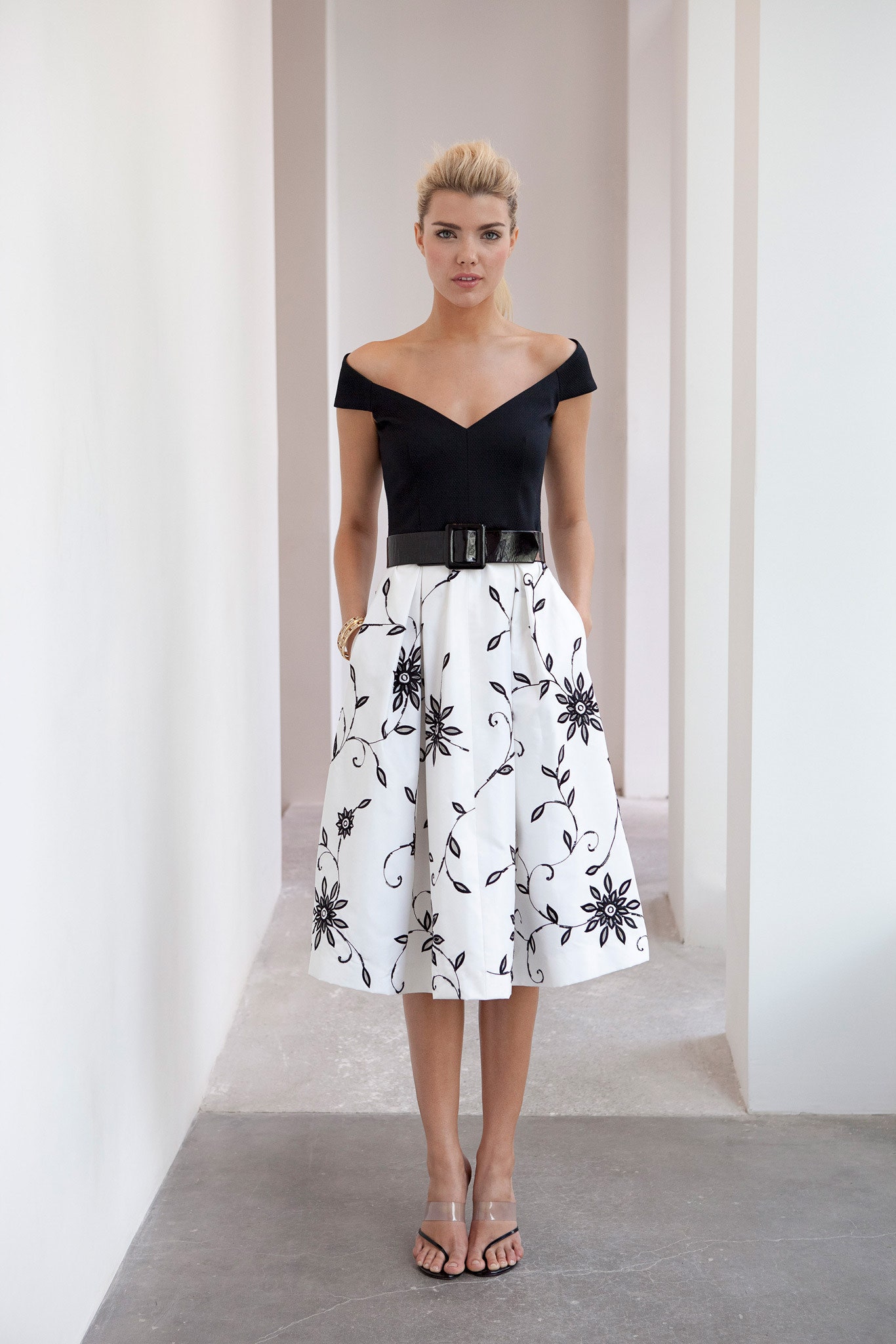 black off-shoulder top with white pleated skirt