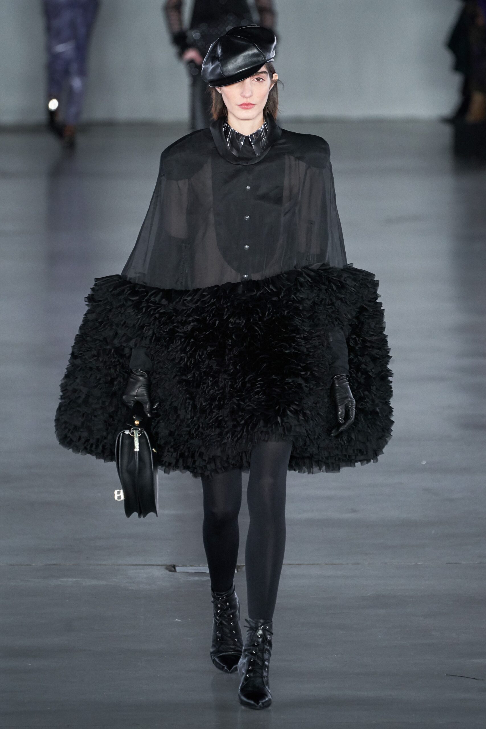 black layered cape and fitted dress