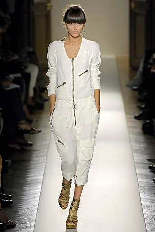 white relaxed jumpsuit with gold shoes