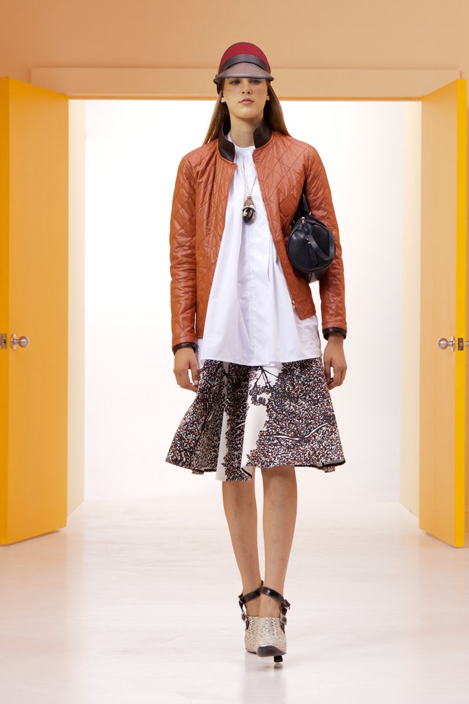 orange quilted jacket with white shirt and flared skirt