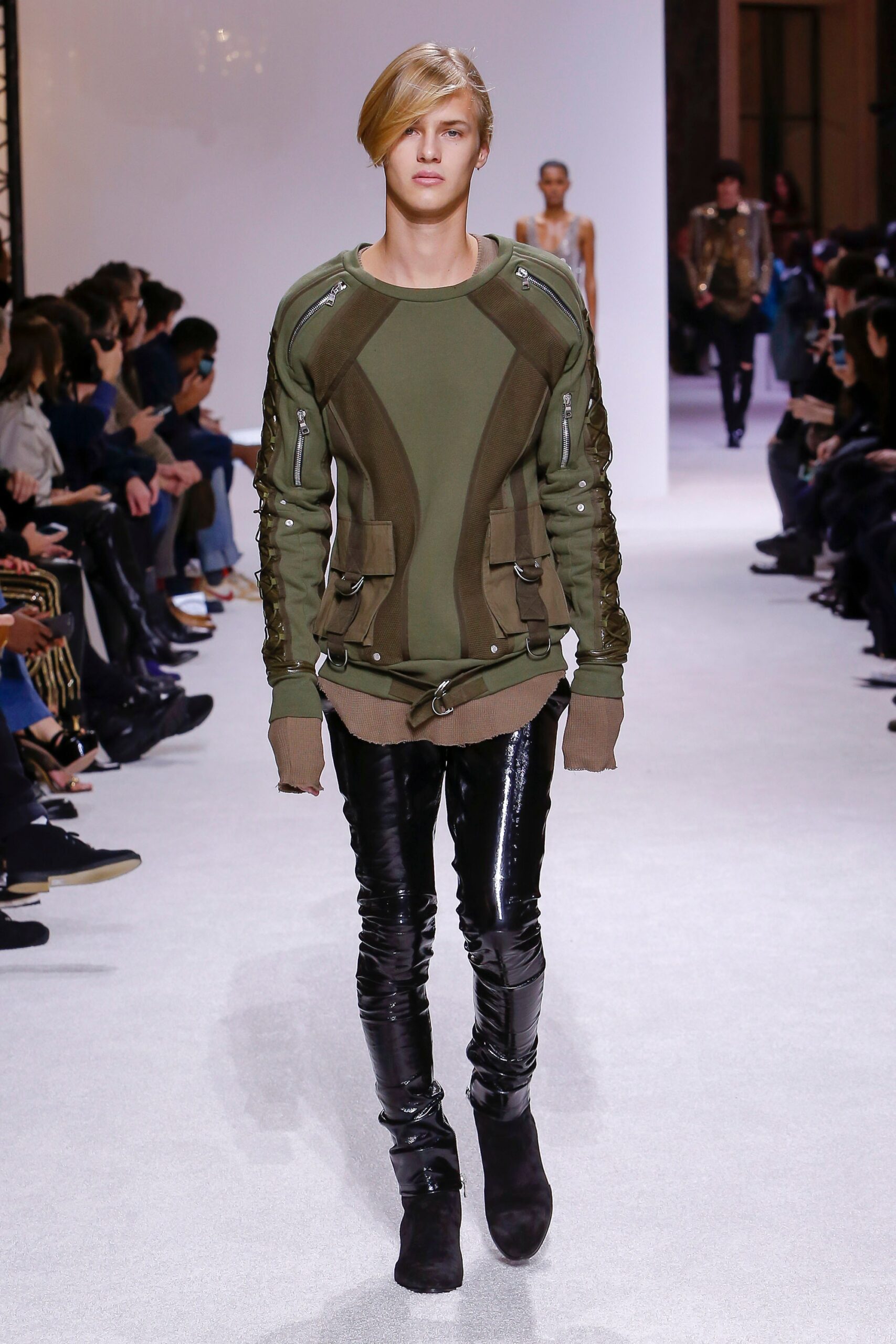 green fitted sweater and black vinyl pants