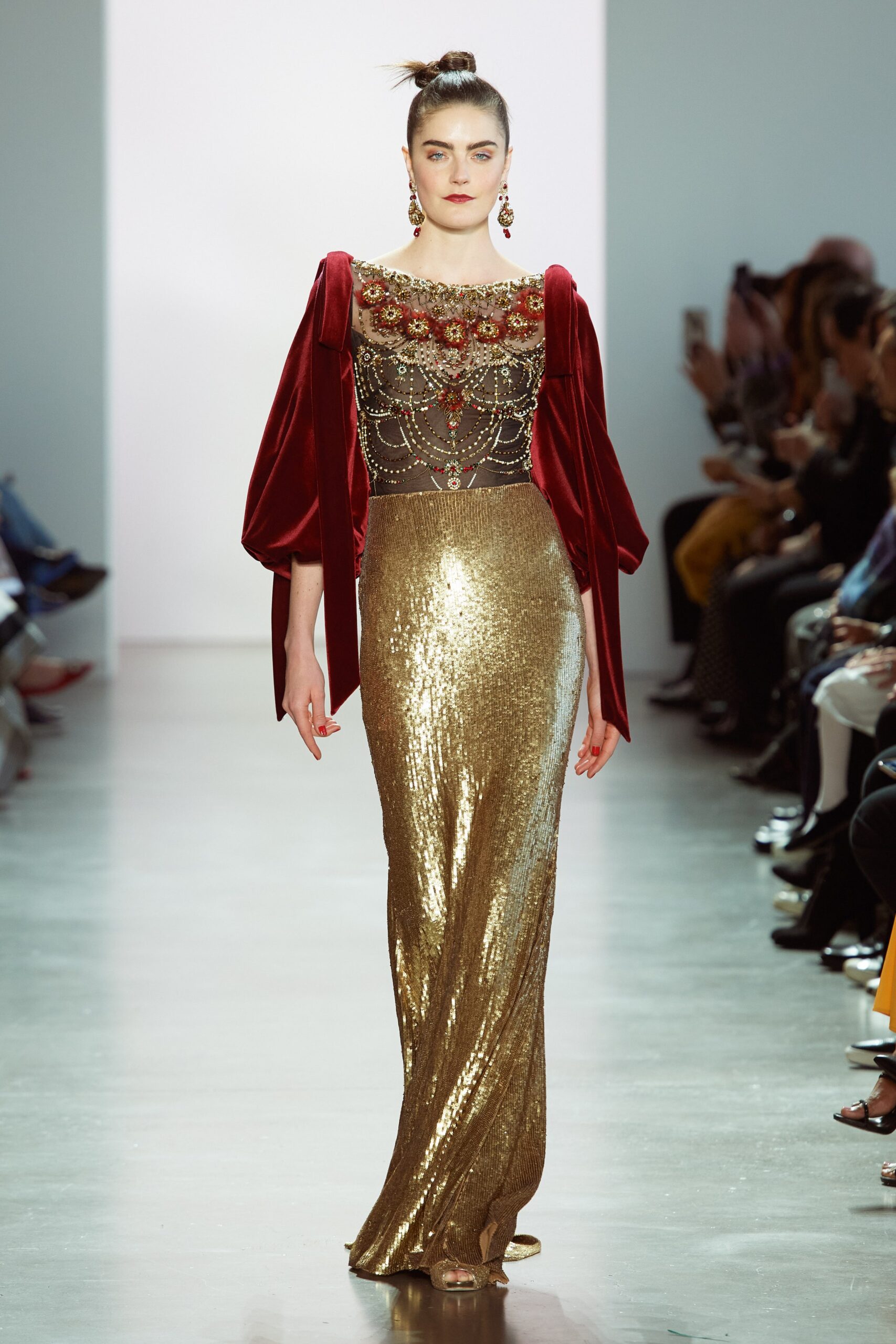 gold sequin gown with red cape