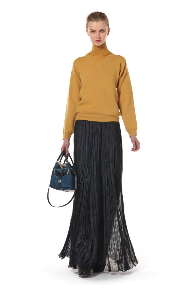 yellow wool relaxed sweater and black pleated skirt