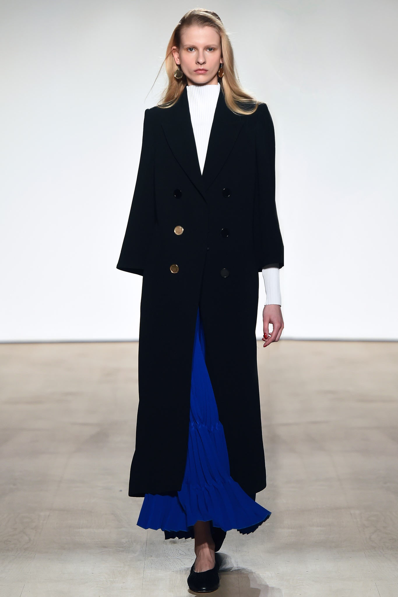 black tailored coat and blue pleated dress