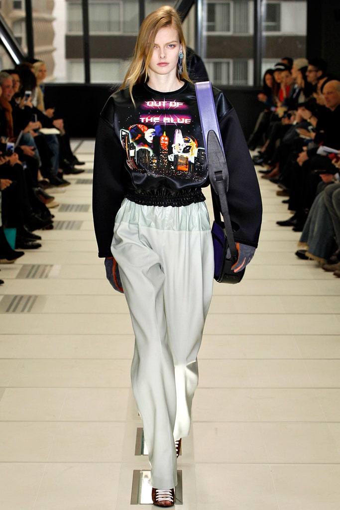 oversized black sweater with printed design and relaxed gray pants