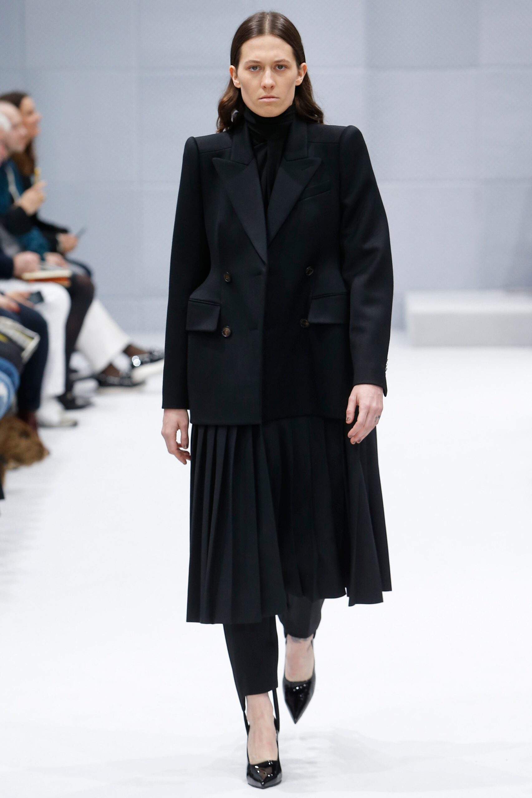 black structured blazer and pleated skirt
