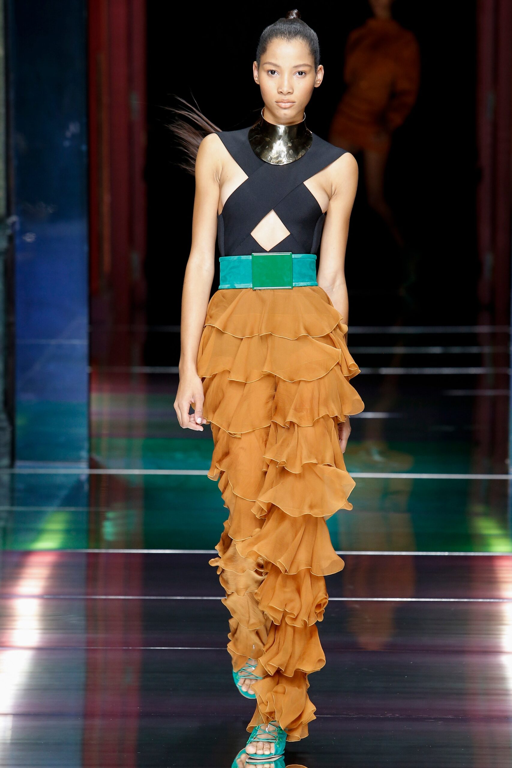 black silk sleeveless top with orange ruffled pants