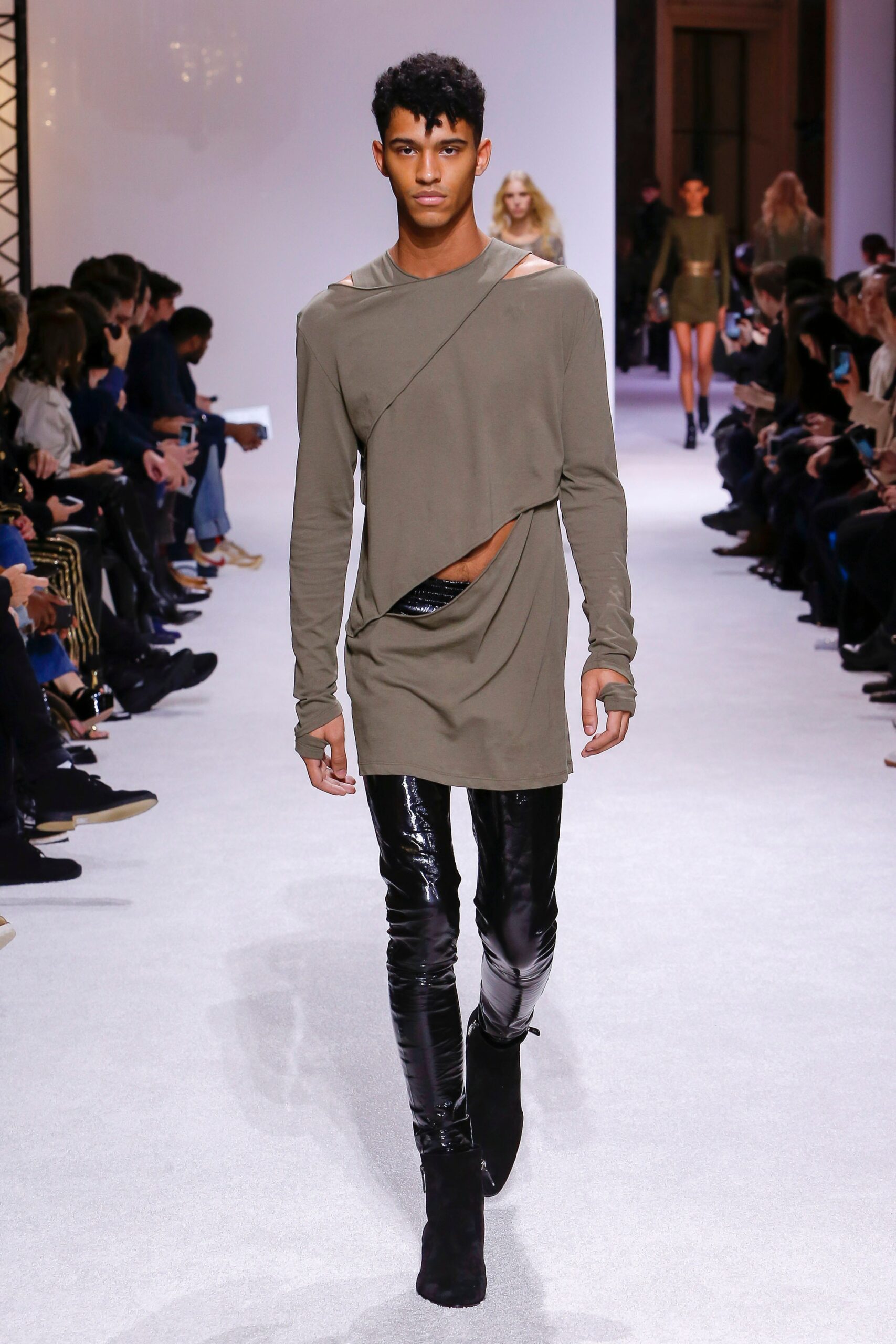 green relaxed top with cutout and black vinyl pants