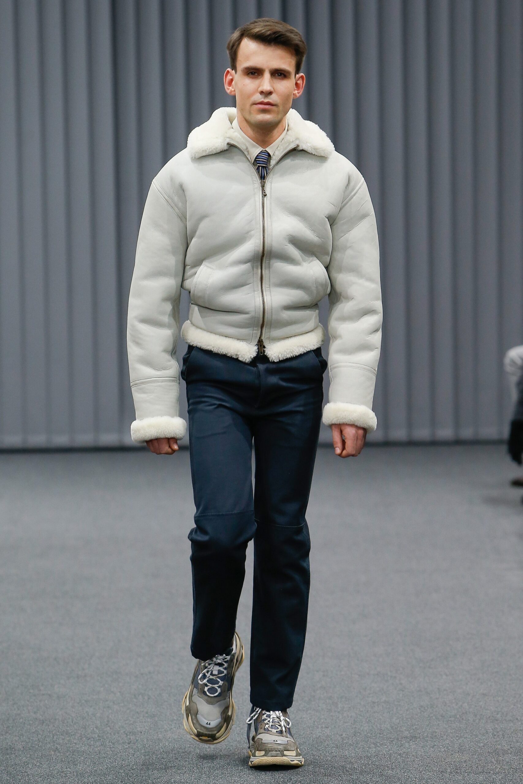 white faux-fur jacket with navy pants