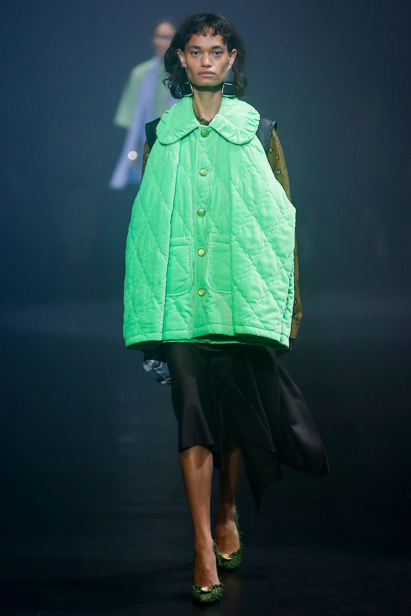 oversized green quilted vest and black asymmetric skirt