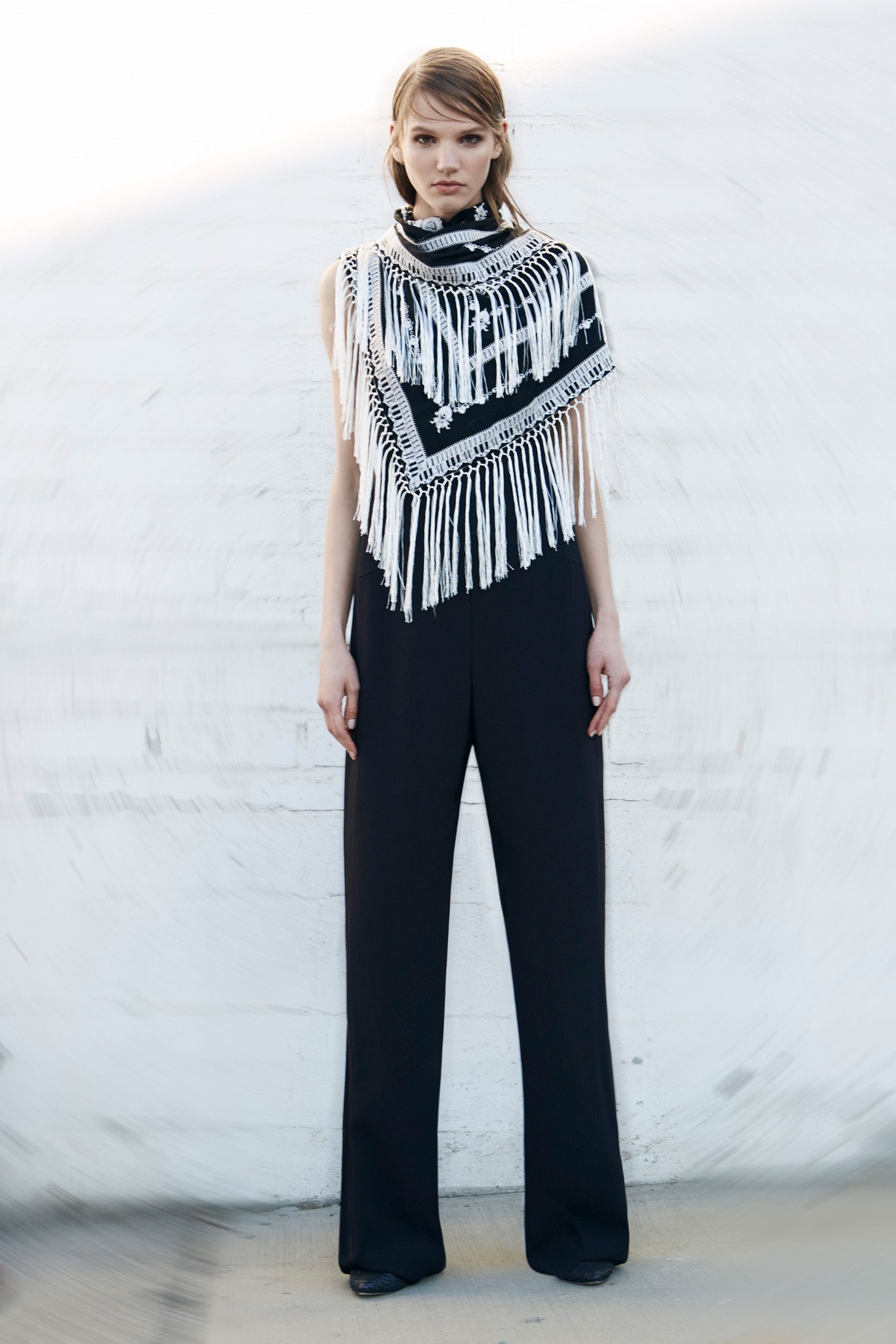 black fitted jumpsuit with fringed cape