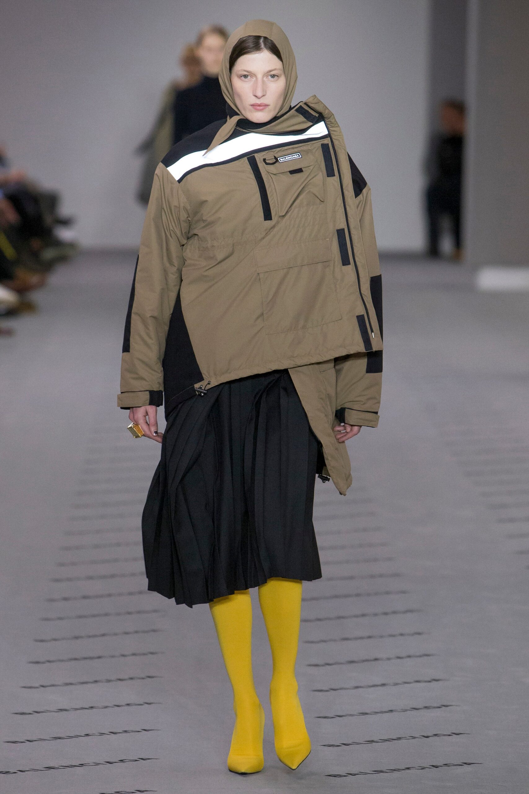 brown relaxed jacket with pleated black skirt