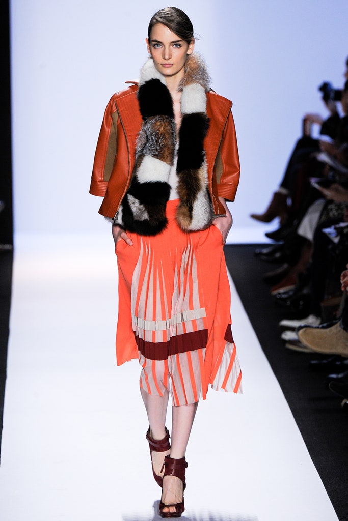 brown leather jacket with fur and orange pleated skirt