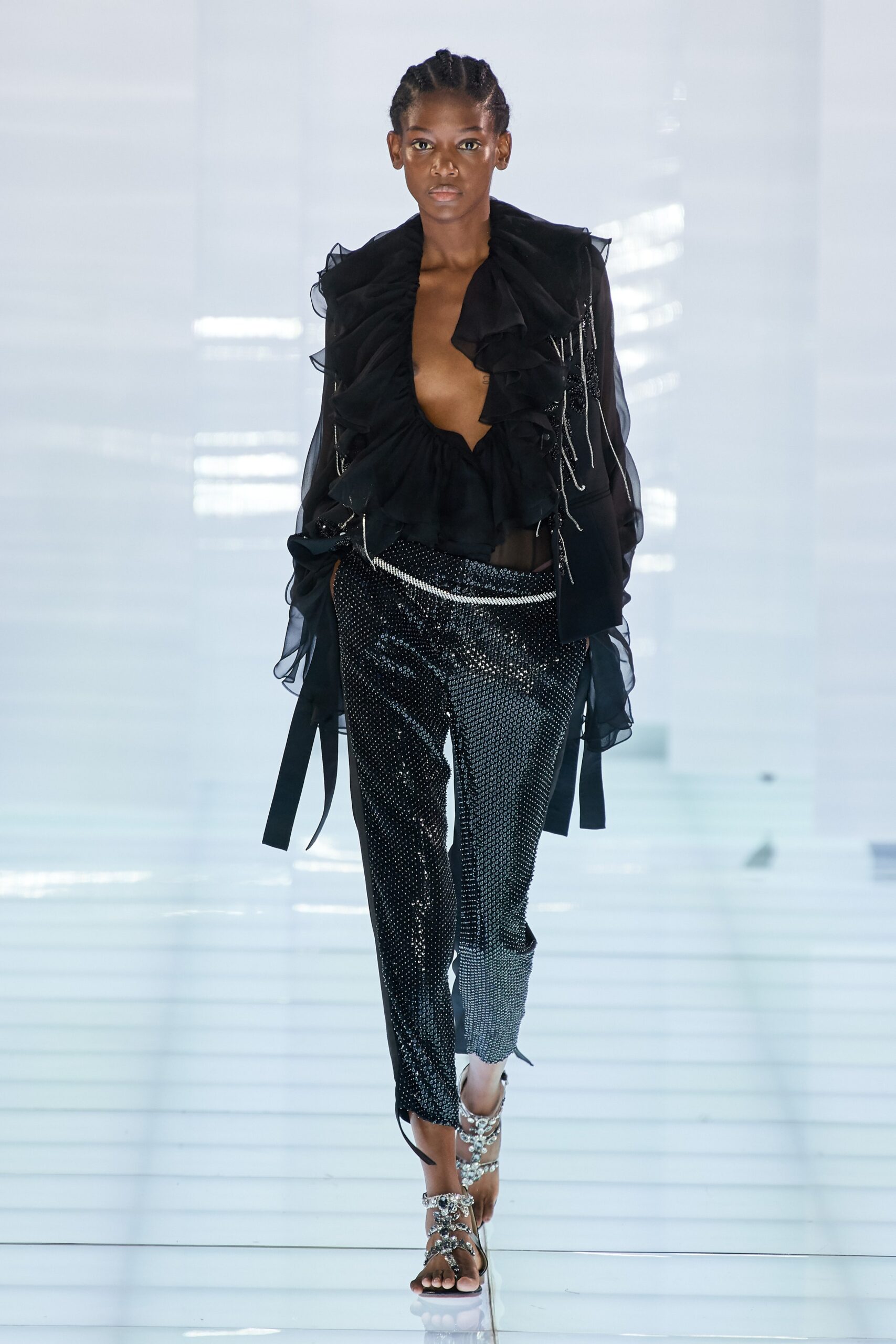 black ruffled top and sequined pants