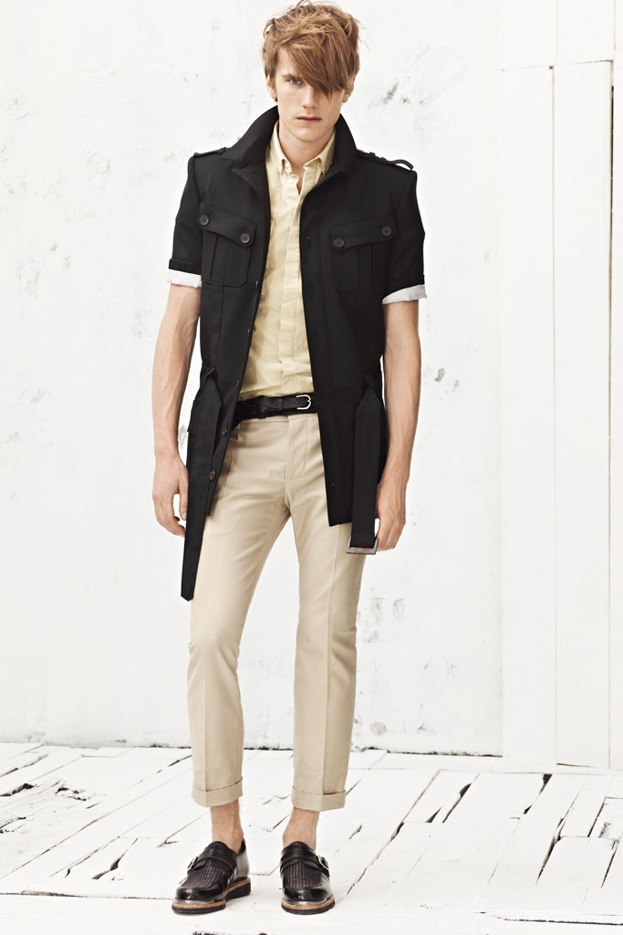black coat yellow shirt beige pants