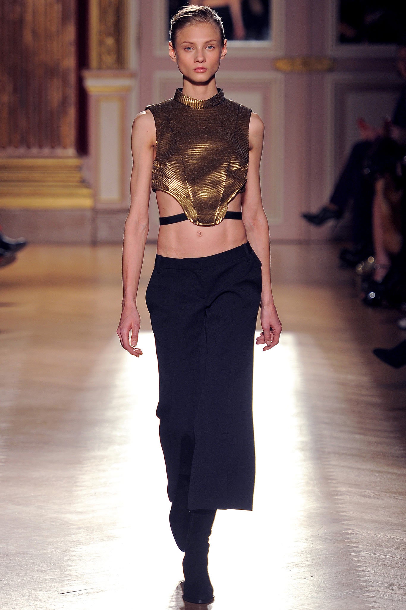 gold fitted sleeveless top and black relaxed pants