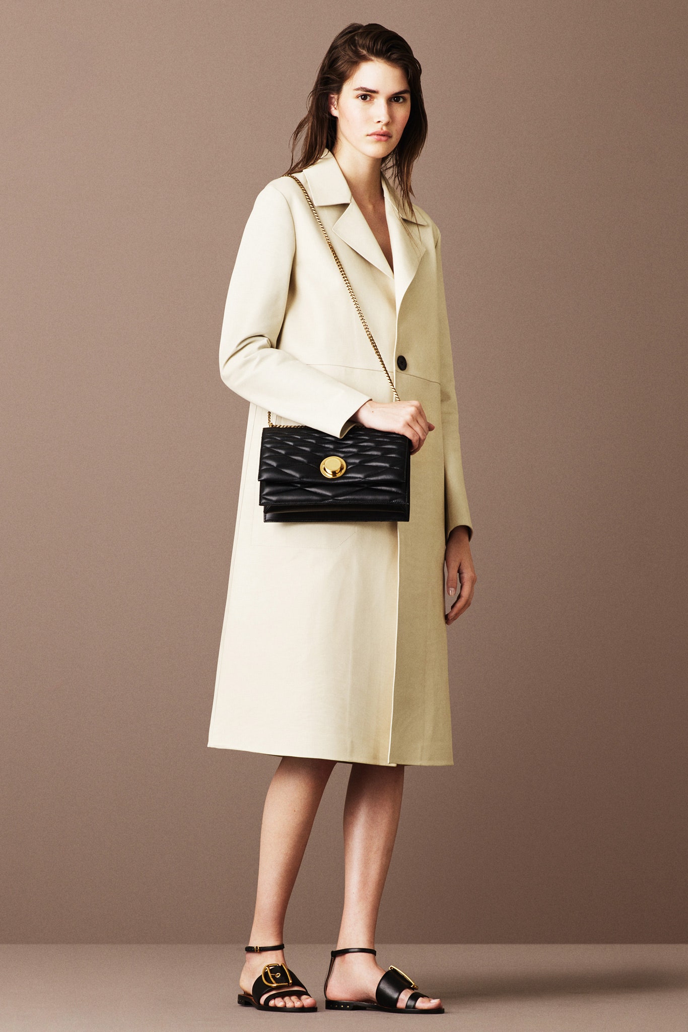 beige fitted coat with black bag
