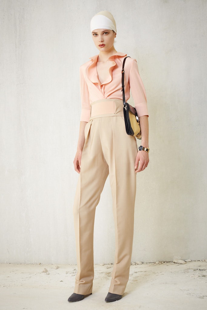 pink silk ruffled blouse and beige tailored pants