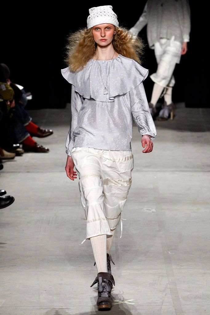 gray ruffled blouse with white pants