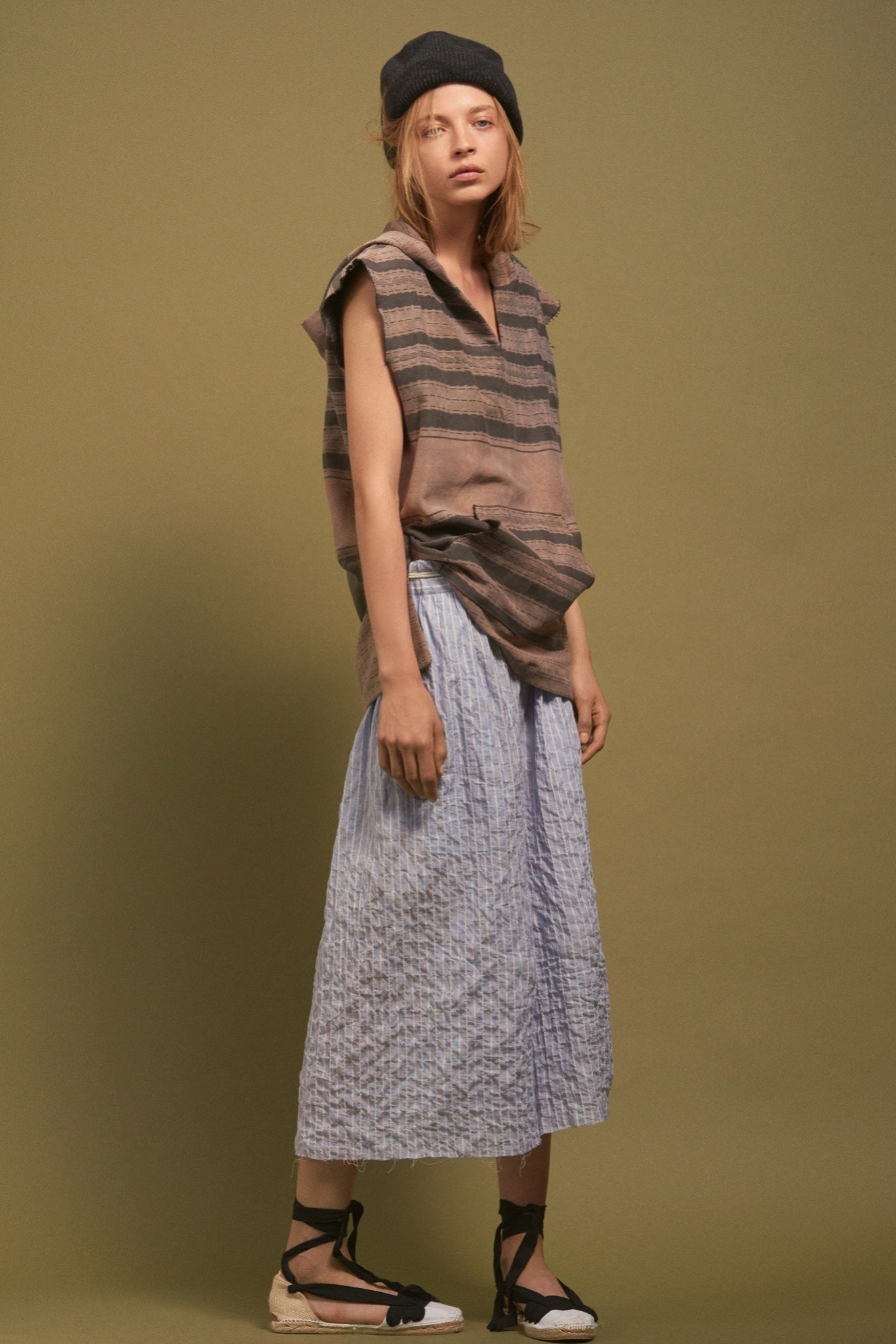 brown striped sleeveless top with blue pleated skirt