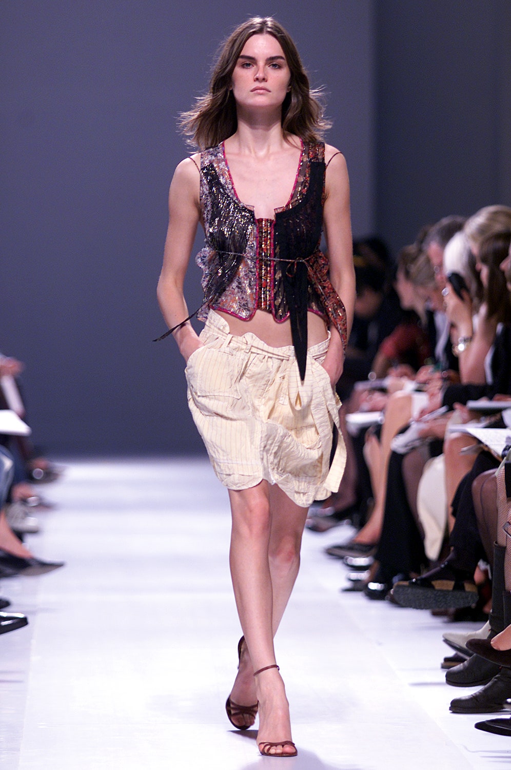 black beaded sleeveless top and beige pleated skirt