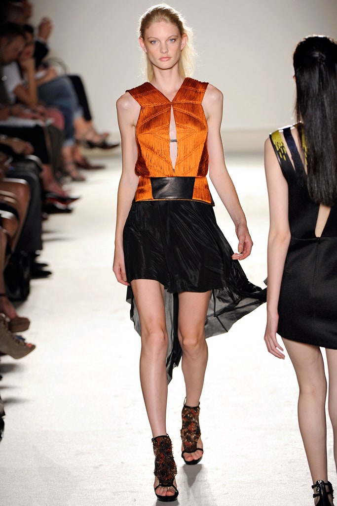 orange pleated top and black skirt